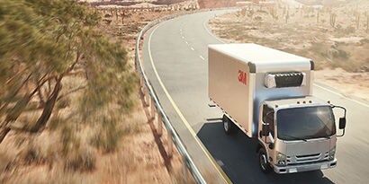 3M branded truck travelling along a roadway with 3M Cooling film applied.
