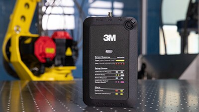 Adhesive Mix Monitor unit in foreground with machine in background.
