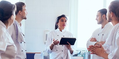 female restaurant team leader working with kitchen staff
