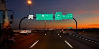 Reflective traffic signage on highway at night.
