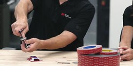 Video still of a 3M Applications Engineer showing the strength of 3M™ VHB™ Tape when bonding two pieces of metal

