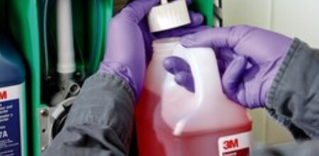 Employee adjusting chemicals in the 3M™ Flow Control Chemical Management dispenser.
