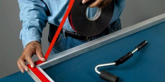 Worker applying 3M™ VHB™ tape to a frame
