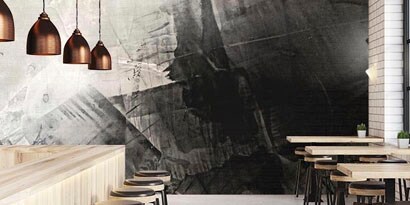 A striking graphic wrap with the appearance of black and white brushstrokes is on the wall of a restaurant.
