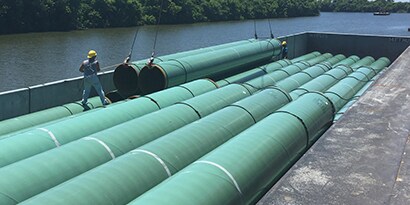 Loading coated pipes onto barge
